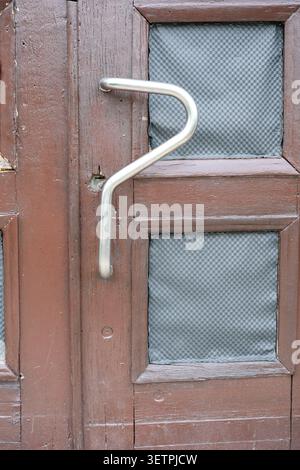 Une poignée en métal créative permet à la porte en bois de se démarquer magnifiquement. Banque D'Images