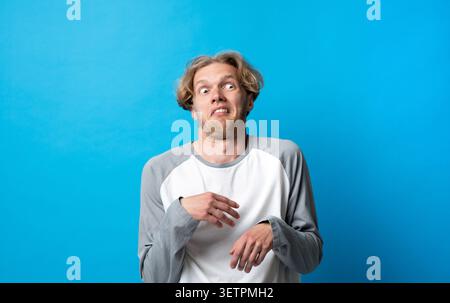 Jeune homme exprimant un fort dégoût et rejet, ressentant une aversion ou une déception avec une expression faciale mécontente et haussant le langage corporel Banque D'Images