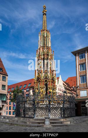 Superbe vue verticale de la célèbre fontaine Schöner Brunnen à Nuremberg. La flèche gothique, riche de statues dorées et de détails colorés, se dresse ma Banque D'Images
