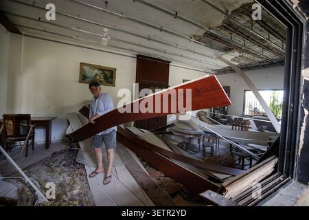 Mayfadoun, Mayfadoun, Liban. 23 juin 2026. HUSSEIN SAFA, libanais, nettoie les décombres de l'intérieur de sa maison dans la ville dévastée de Mayfadoun, au sud du Liban, provoquée par les frappes aériennes israéliennes. Des dizaines de Libanais qui avaient fui leurs villages ont commencé à rentrer pour faire face au choc dévastateur de voir leurs maisons complètement démolies. À la suite du récent accord américano-iranien, les résidents ont tenté de rentrer, mais ont été accueillis par des scènes de gravats et de cendres. (Crédit image : © Marwan Naamani/ZUMA Press Wire) USAGE ÉDITORIAL SEULEMENT ! Non destiné à UN USAGE commercial ! Banque D'Images