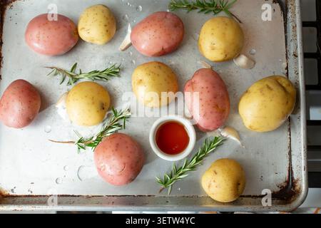 Une vue de haut en bas des ingrédients sur un plateau, en préparation de pommes de terre rôties au miel. Banque D'Images