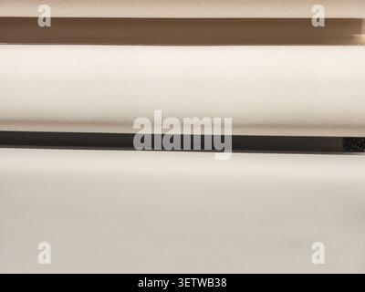 Une vue rapprochée de plusieurs rouleaux de tissu, affichant une variété de textures et de couleurs neutres, parfait pour l'inspiration de design d'intérieur Banque D'Images