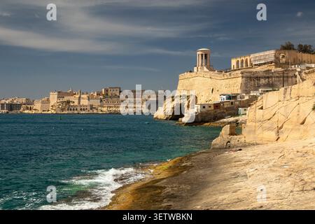 Malte, la Valette, la côte sud inférieure de Barrakka Mémorial de la cloche du siège sur le bastion de St Christopher au-dessus de Grand Harbour et de la plage de Wuestenwinds Banque D'Images