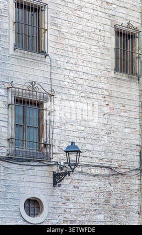 Ancien mur de bâtiment avec des grilles de fer ornées à Barcelone Banque D'Images