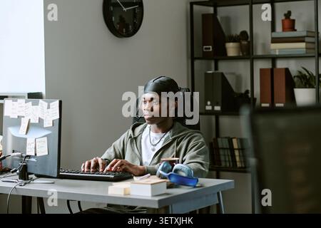 Homme noir travaillant à l'ordinateur de bureau dans le bureau à domicile Banque D'Images