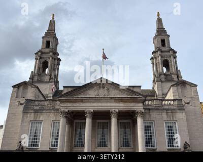 La façade néoclassique du Leeds Civic Hall, avec des tours jumelles, de la maçonnerie en pierre et des drapeaux nationaux, est située à Leeds, au Royaume-Uni. Banque D'Images