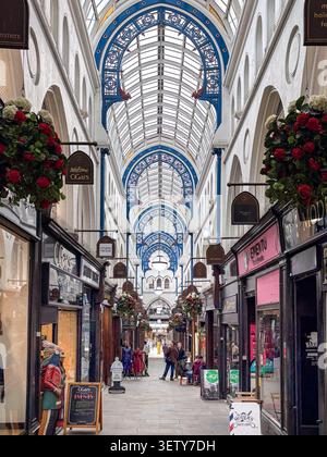 Vue sur la galerie marchande intérieure victorienne historique de Leeds, West Yorkshire, Angleterre, avec toit en verre décoratif et devantures de magasins. Banque D'Images