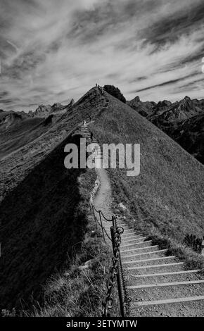 Garde-corps à chaîne commande le premier plan alors que l'escalier de crête Stoos se dissout doucement dans le ciel monochrome au-delà Banque D'Images