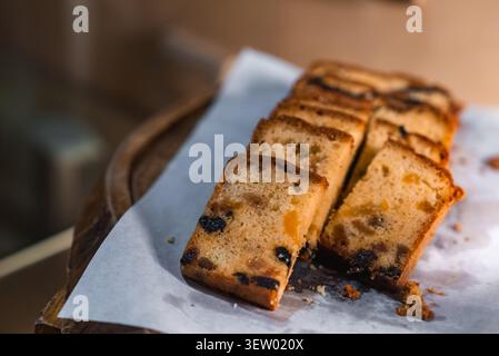 Gâteau aux fruits tranchés sur parchemin avec raisins secs et orange confite Banque D'Images