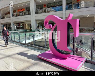 Une grande sculpture rose en forme de T se dresse sur une plate-forme à l'intérieur de Trinity Leeds, un centre commercial moderne à plusieurs niveaux à Leeds, au Royaume-Uni. Banque D'Images