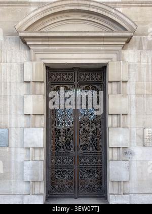 Portes d'entrée ornées en fer forgé situées dans une façade en pierre au Leeds Civic Hall, Leeds, West Yorkshire, Royaume-Uni. Banque D'Images