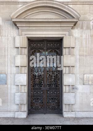 Portes doubles en fer forgé ornées situées dans une arche néoclassique en calcaire du Leeds Civic Hall, Leeds, Angleterre. Banque D'Images