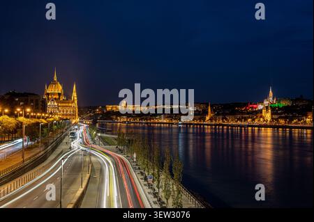 Vue élevée des traînées de feux de circulation en exposition longue le long du Danube avec le Parlement hongrois illuminé et le quartier du château de Buda la nuit Banque D'Images