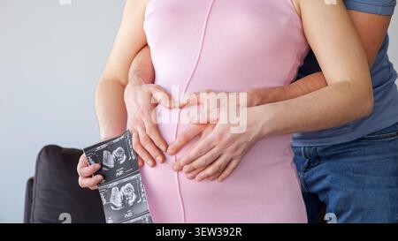 Futurs parents en échographie formant coeur Banque D'Images