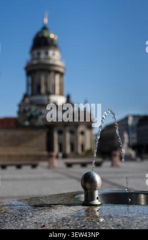 Fontaine d'eau potable publique au Gendarmenmarkt devant la cathédrale française de Berlin, en Allemagne, par une chaude journée d'été. Banque D'Images
