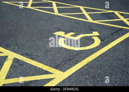 place de parking handicapés peinte sur la route en jaune. Banque D'Images