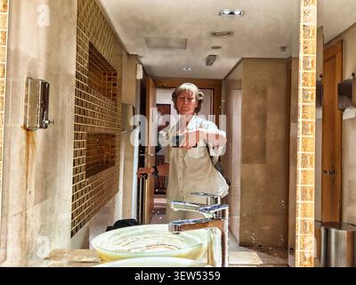 Femme profitant d'un moment dans une salle de bain, prenant un selfie avec un smartphone tout en étant habillée de façon décontractée et à l'air détendu Banque D'Images