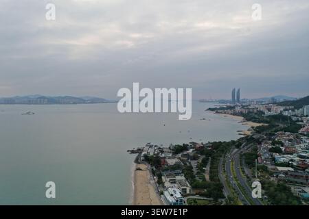 Superbe vue aérienne d'un village balnéaire niché entre plages de sable immaculées et eaux turquoises calmes. La scène capture des coas traditionnels Banque D'Images