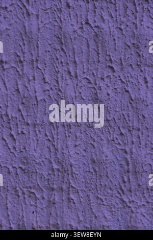 Gros plan détaillé d'un mur de stuc texturé violet vibrant avec un motif rainuré vertical rugueux. Ce surf en béton abstrait unique en plâtre Banque D'Images