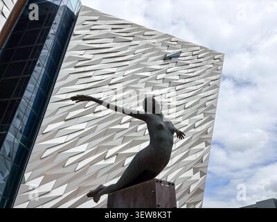 Sculpture de la déesse de la mer devant la façade géométrique du musée Titanic Belfast. Titanic Quarter, Belfast, Irlande du Nord. Banque D'Images