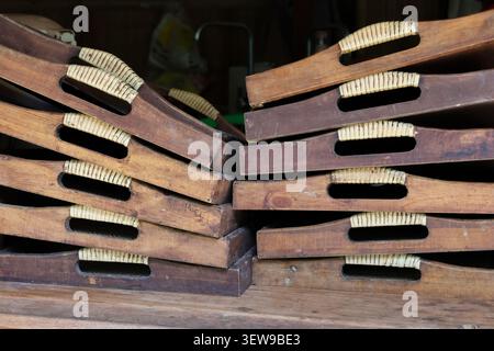 Plateaux en bois empilés avec poignées en corde tissée, style rustique et vintage, disposés en deux piles sur une surface en bois, adaptés pour nous servir ou nous décorer Banque D'Images