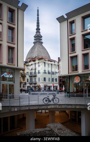 Vue de la mole Antonelliana encadrée par des bâtiments contemporains dans le centre de Turin, Italie. Le dôme emblématique et la flèche montante s'élèvent au-dessus d'un resi historique Banque D'Images
