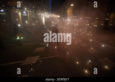 Feux d'artifice et fumée remplissent la rue pendant le spectacle Correfoc. Valence, Espagne - 16 mars 2024. Banque D'Images