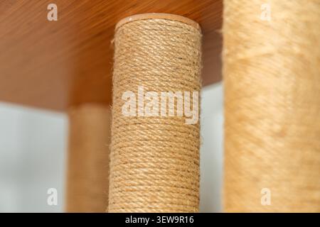 Close up d'un arbre à chat en corde de sisal posé sur des meubles en bois. Accessoire moderne respectueux de l'environnement pour chats et griffoir félin pour les intérieurs de maison. Banque D'Images