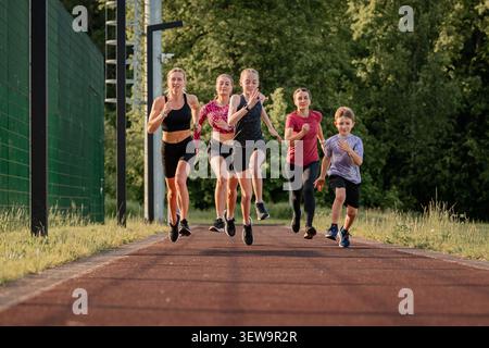 Groupe de coureurs s'entraînant ensemble sur une piste extérieure Banque D'Images
