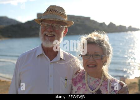 Heureux couple senior souriant ensemble sur des vacances ensoleillées à la plage Banque D'Images