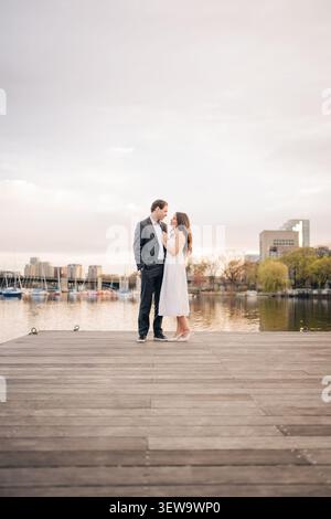 Couple aimant debout sur le quai, embrassant à boston Banque D'Images