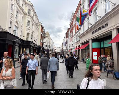 Rue commerçante bondée sur Grafton Street. Dublin, Irlande. Les clients passent devant le grand magasin de luxe Brown Thomas. Banque D'Images