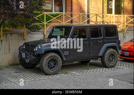 24 juin 2026, Tbilissi, Géorgie Un Jeep Wrangler Unlimited Sport noir, faisant partie de l'iconique génération JK, garé dans un cadre extérieur et équipé de Banque D'Images