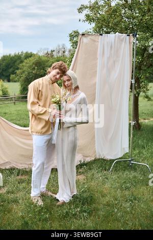 Couple élégant profite d'un moment tendre ensemble tout en étant entouré par la nature Banque D'Images