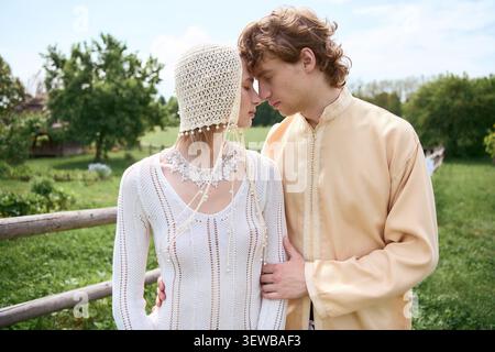 Jeune couple dans des tenues boho profite d'un moment tendre entouré par la beauté des natures Banque D'Images