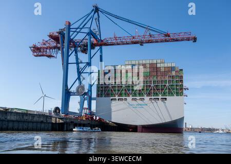 Hambourg, Allemagne - 4 avril 25 : grand porte-conteneurs OOCL Denmark amarré à un terminal à conteneurs de Hambourg avec grues et éolienne visible, Allemagne. Banque D'Images