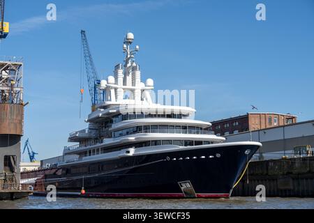 Hambourg, Allemagne - 4 avril 25 : Grand superyacht moderne amarré à un quai dans le port de Hambourg sur l'Elbe, Allemagne, sous un ciel bleu clair. Banque D'Images