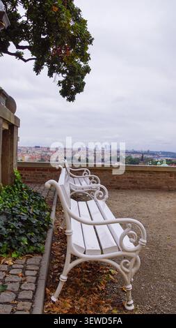 Banc vide en bois blanc sur une terrasse en pierre surélevée donnant sur le panorama de la ville, Prague, République tchèque Banque D'Images
