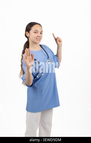 Infirmière joyeuse pointant du doigt la publicité du service de santé en studio Banque D'Images