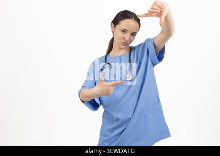 Infirmière souriante faisant des gestes de bordure de cadre photo à l'aide de ses mains Banque D'Images