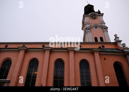 Stockholm, Suède-Nov.27th 2025 : vue en angle bas du mur extérieur rose, des rangées de fenêtres cintrées et de la tour de l'horloge baroque de Storkyrkan Banque D'Images