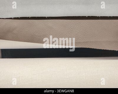 Trois textures de tissu différentes sont empilées, présentant un faux cuir gris clair, un matériau texturé beige et un textile tissé crème Banque D'Images