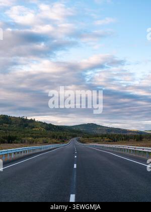Une longue autoroute ouverte traverse une région montagneuse pittoresque. Banque D'Images