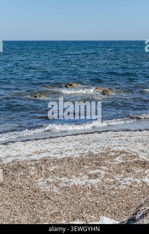 Paysage avec du sable blanc et skerry dans l'eau bleue à la plage de sable sur la rive de la mer Méditerranée, tourné dans la lumière brillante du printemps à la plage de Matta e Peru, n Banque D'Images
