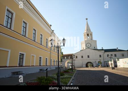 Kazan, Russie - 28.05.2026 : Tour de l'horloge blanche historique et bâtiment classique jaune dans la cour ensoleillée Banque D'Images