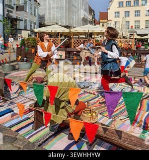 Tallinn, Estonie - 15 août 2020 : deux enfants en costumes médiévaux se livrent à une bagarre à l'épée ludique sur un étal de marché, Medieval Days Banque D'Images