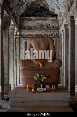 Statue de Bouddha assise sans tête sur le trône de Naga au temple Ta Prohm, Cambodge Banque D'Images