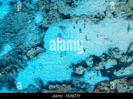 Vue aérienne de haut en bas des gens nageant dans la mer turquoise claire Banque D'Images