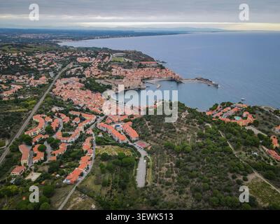 Un drone aérien capture la charmante ville côtière de Collioure, en France, avec ses bâtiments aux toits en terre cuite typiques regroupés autour d'un Banque D'Images