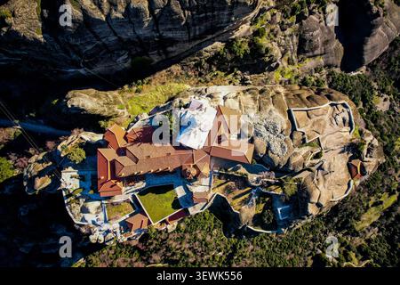 Un drone aérien capture le monastère de Roussanou, avec ses toits en terre cuite distinctifs et son dôme blanc, niché au sommet d'un pilier rocheux massif à M. Banque D'Images